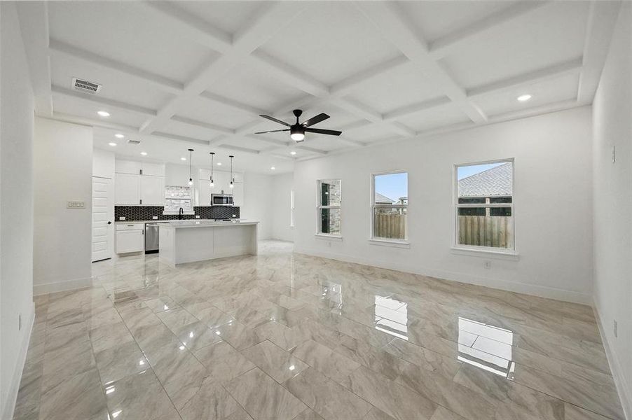 Unfurnished living room featuring light marble finish floors, coffered ceiling, ceiling fan, beamed ceiling, and recessed lighting