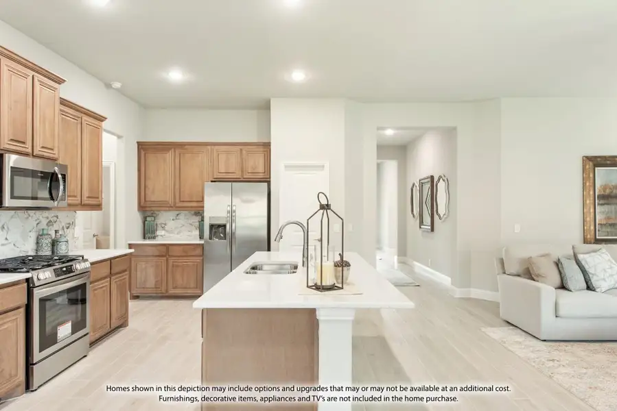 Open kitchen with wood cabinets, center island, stainless appliances, and light floors opening to living area Open kitchen with wood cabinets, center island, stainless appliances, and light floors opening to living area