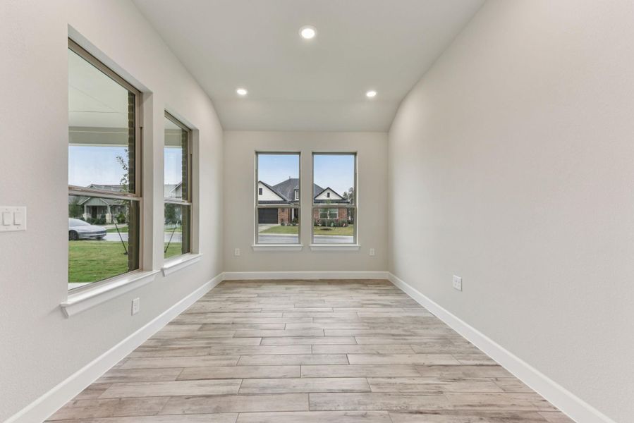 Empty room with light wood-style floors, healthy amount of natural light, and recessed lighting