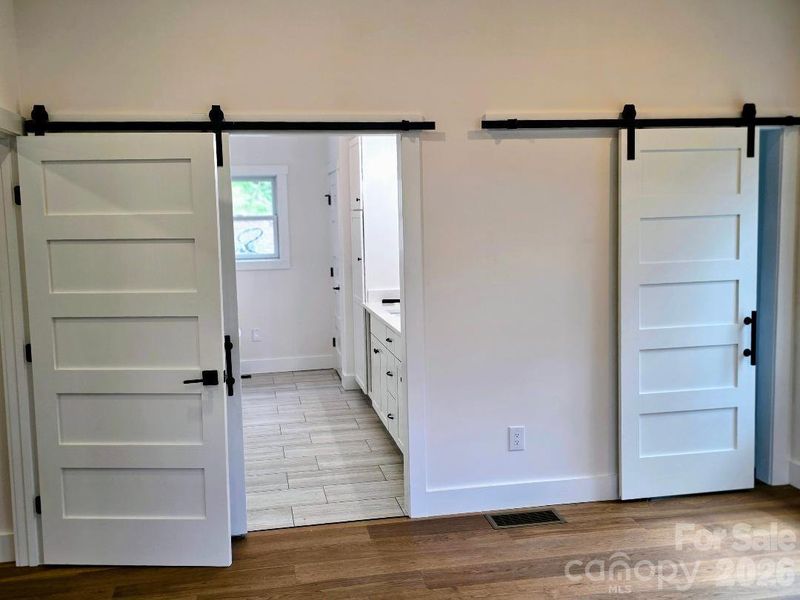 Primary bedroom with barn doors for ensuite bathroom and walk-in closet