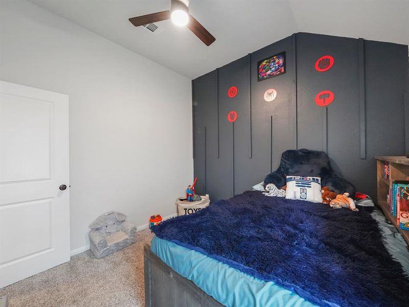 The second bedroom offers high ceilings, a blue accent wall, and a new fan.