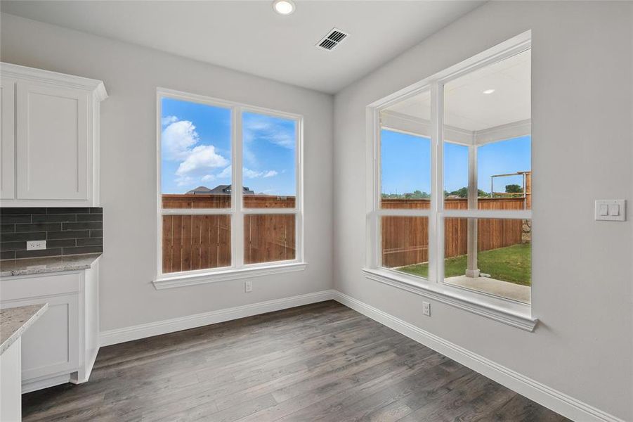 Unfurnished dining area with baseboards, dark wood-style flooring, and recessed lighting Unfurnished dining area with baseboards, dark wood-style flooring, and recessed lighting