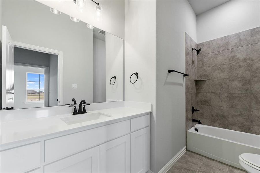 Full bathroom with washtub / shower combination, vanity, and light tile patterned flooring Full bathroom with washtub / shower combination, vanity, and light tile patterned flooring