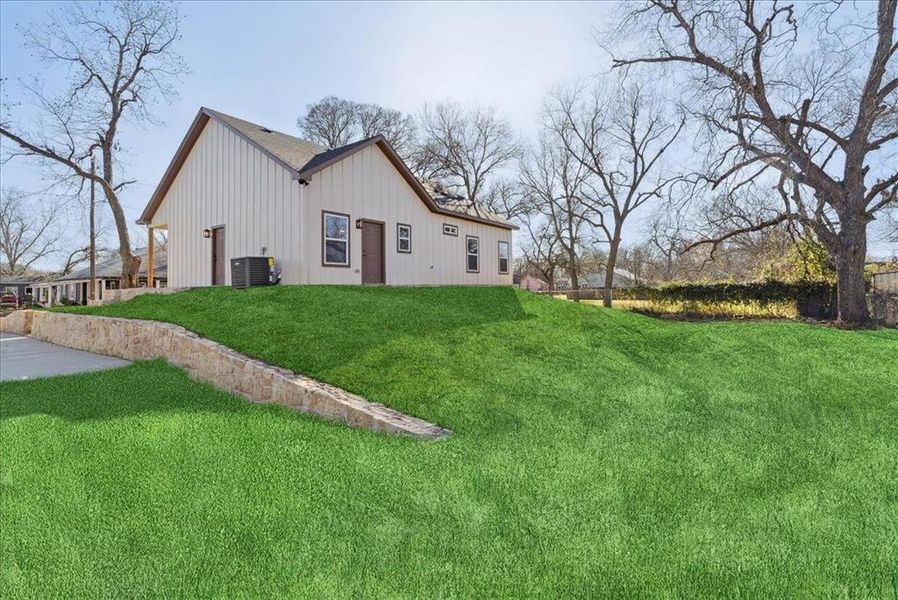 View of home's exterior featuring central AC unit and a lawn