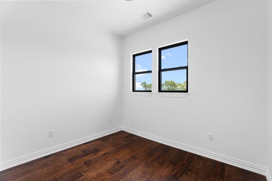 Empty room with baseboards and dark wood finished floors Empty room with baseboards and dark wood finished floors