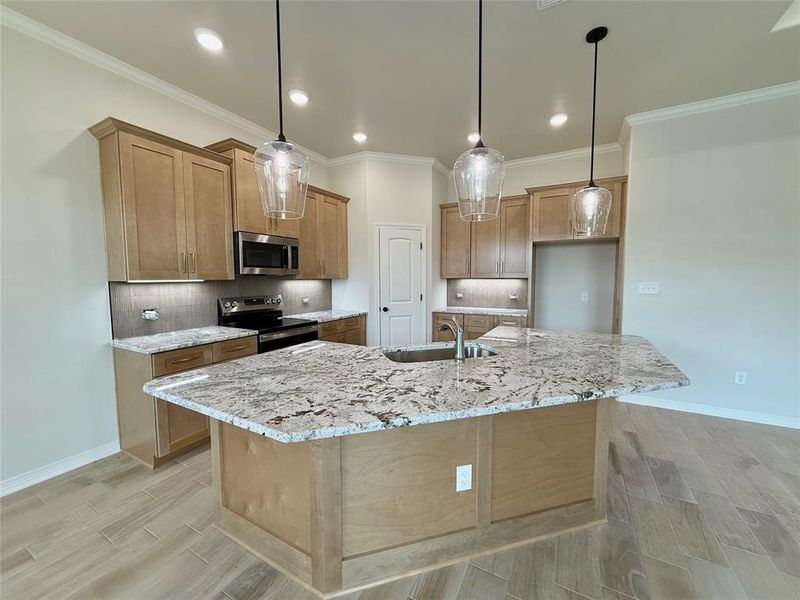 Kitchen with stainless steel appliances, wood finish floors, light stone countertops, backsplash, and recessed lighting