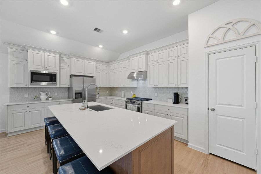 The kitchen is well-lit with recessed lighting and has light wood flooring, offering a bright and inviting space. The kitchen is well-lit with recessed lighting and has light wood flooring, offering a bright and inviting space.