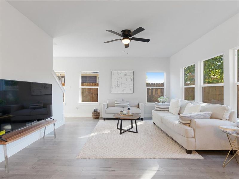 Living room with light wood-type flooring and ceiling fan