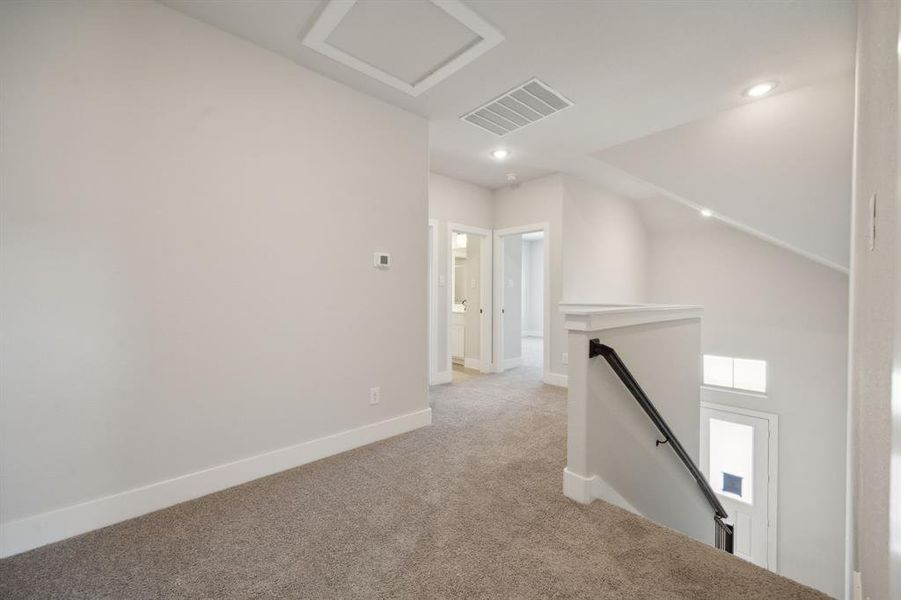 Hall featuring light colored carpet and vaulted ceiling