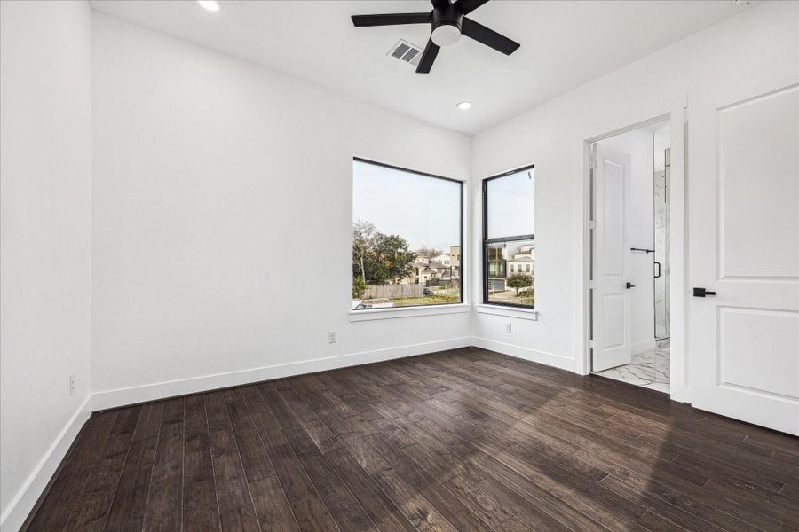 This front-facing secondary bedroom is filled with sunlight, creating a cheerful and welcoming space for family or guests.