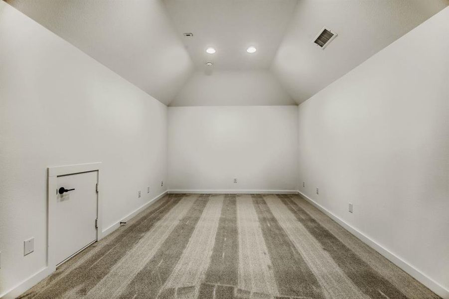 Bonus room featuring light carpet and vaulted ceiling