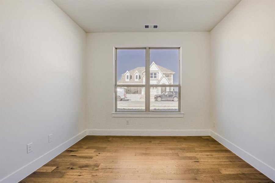 Spare room featuring light wood-type flooring and baseboards