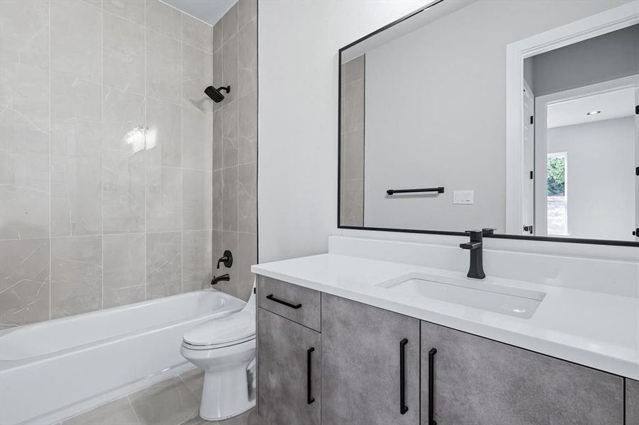 Bathroom featuring vanity, washtub / shower combination, and tile patterned flooring Bathroom featuring vanity, washtub / shower combination, and tile patterned flooring