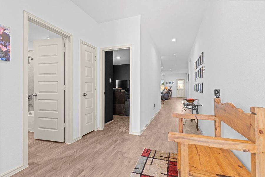 Follow the hallway lined with elegant 5-panel shaker interior doors and durable wood-look vinyl floors that blend style with easy maintenance. This well-planned layout guides you toward the main living spaces while keeping secondary rooms tucked away for privacy. Follow the hallway lined with elegant 5-panel shaker interior doors and durable wood-look vinyl floors that blend style with easy maintenance. This well-planned layout guides you toward the main living spaces while keeping secondary rooms tucked away for privacy.