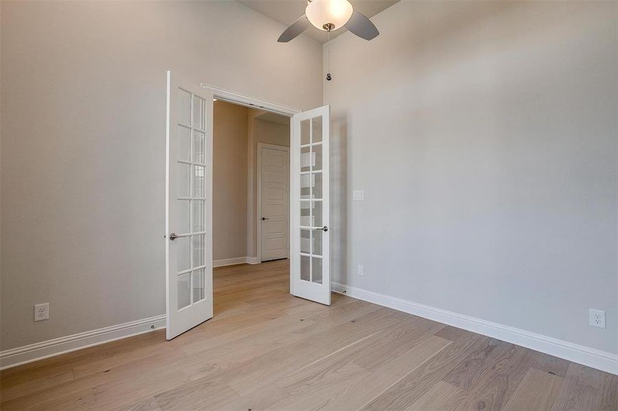 Spare room featuring french doors, ceiling fan, and light hardwood / wood-style flooring