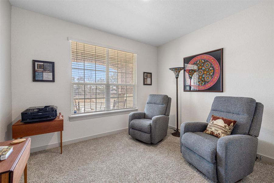 Living area featuring light colored carpet and baseboards Living area featuring light colored carpet and baseboards