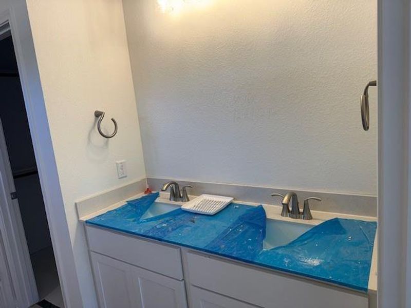 Bathroom with double vanity and a textured wall Bathroom with double vanity and a textured wall