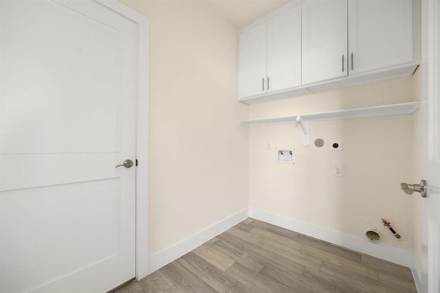 Convenient laundry room with ample space for washer and dryer, built-in shelving, and a clean, functional design.