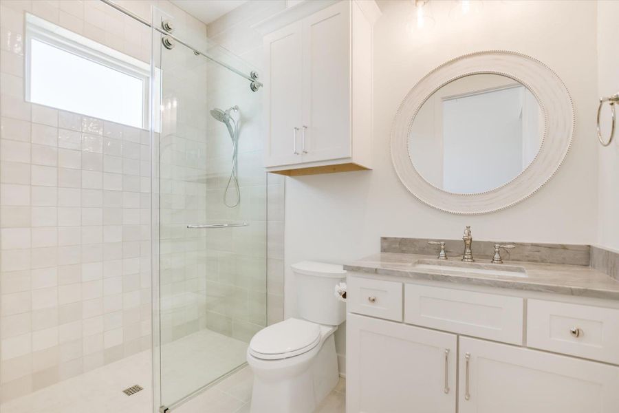 Full bathroom with a shower stall, vanity, and toilet Full bathroom with a shower stall, vanity, and toilet