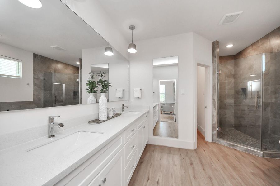 The large mirror hanging above the sinks, plus the full body mirror, reflect the room's soft lighting. The large mirror hanging above the sinks, plus the full body mirror, reflect the room's soft lighting.