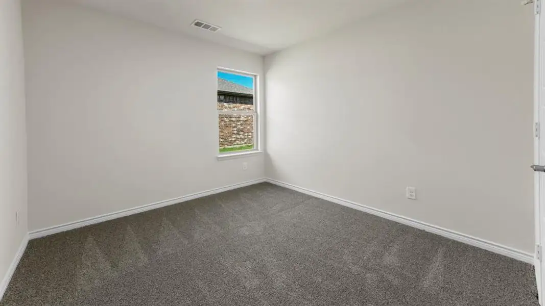 Neutral tone walls with white trim, gray carpet flooring, and a single window