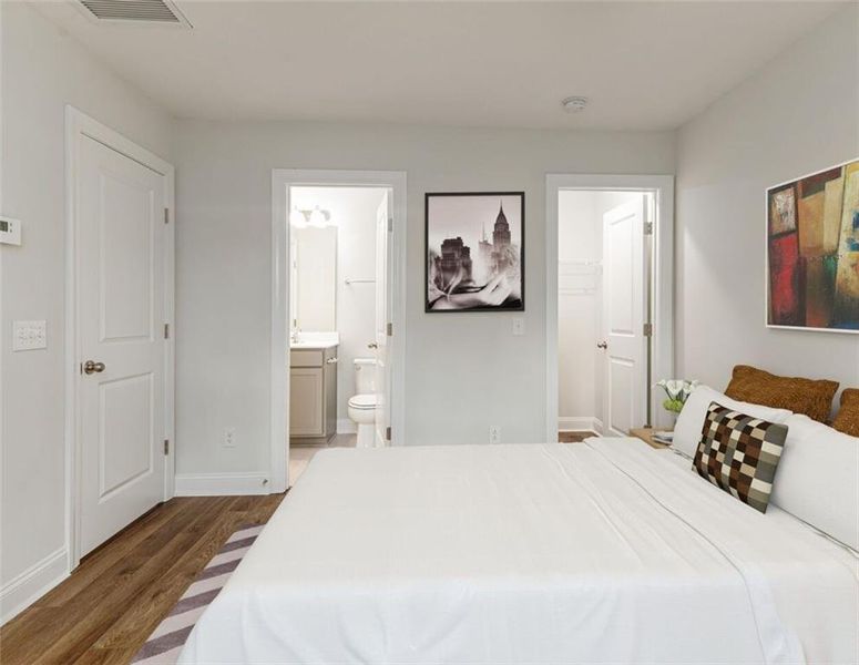 Bedroom with dark hardwood / wood-style floors and ensuite bathroom