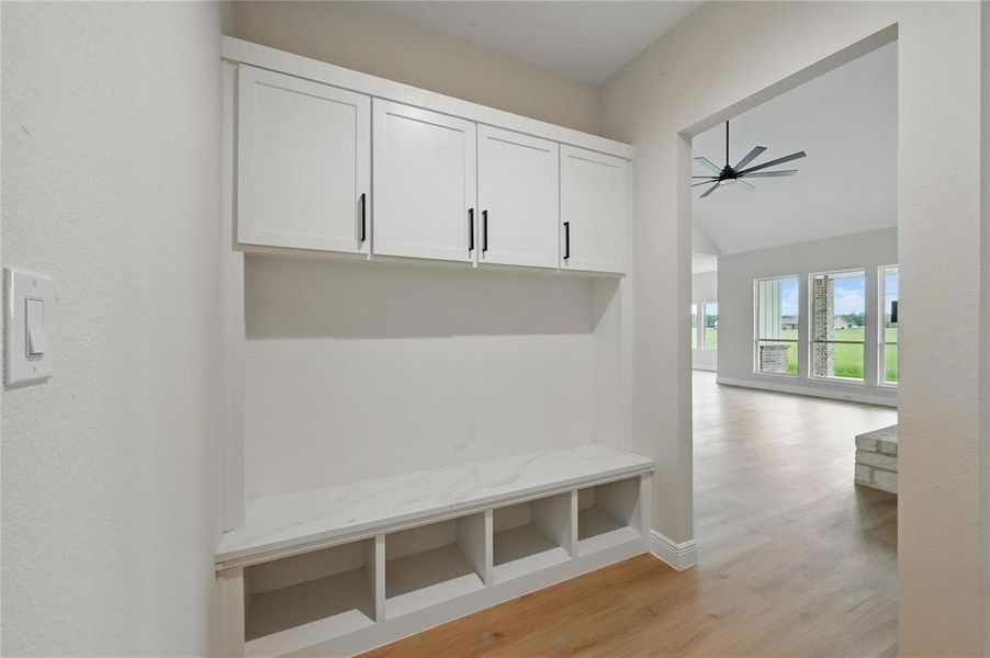 Mudroom featuring light wood-style flooring and vaulted ceiling Mudroom featuring light wood-style flooring and vaulted ceiling