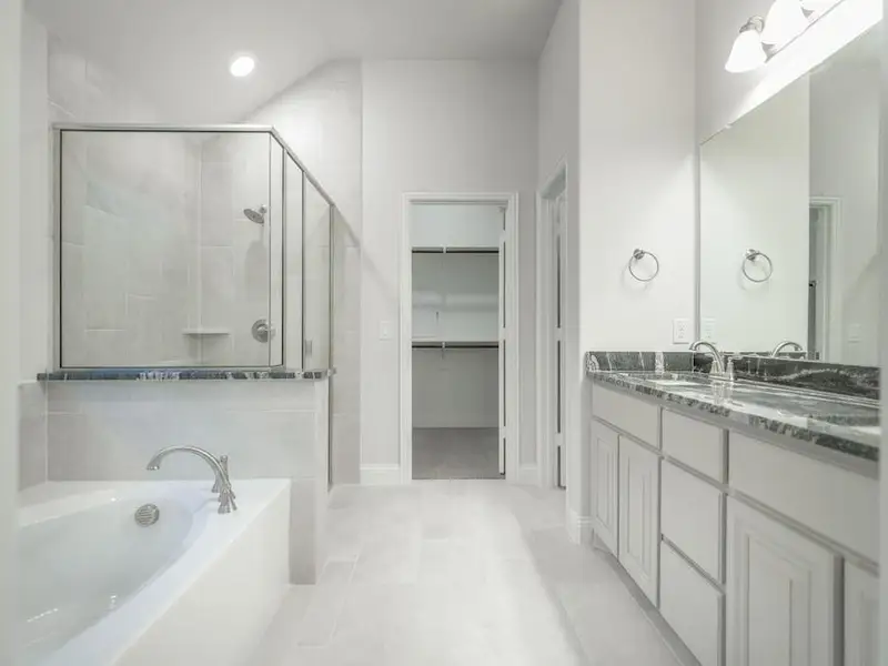 Bathroom featuring plus walk in shower, vanity, and tile patterned floors