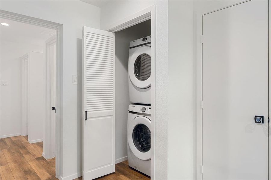 Stacked washer & dryer units and a storage closet next to it.
