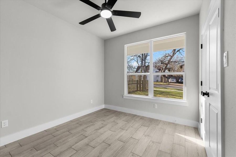 Spare room featuring ceiling fan, wood finished floors, and baseboards