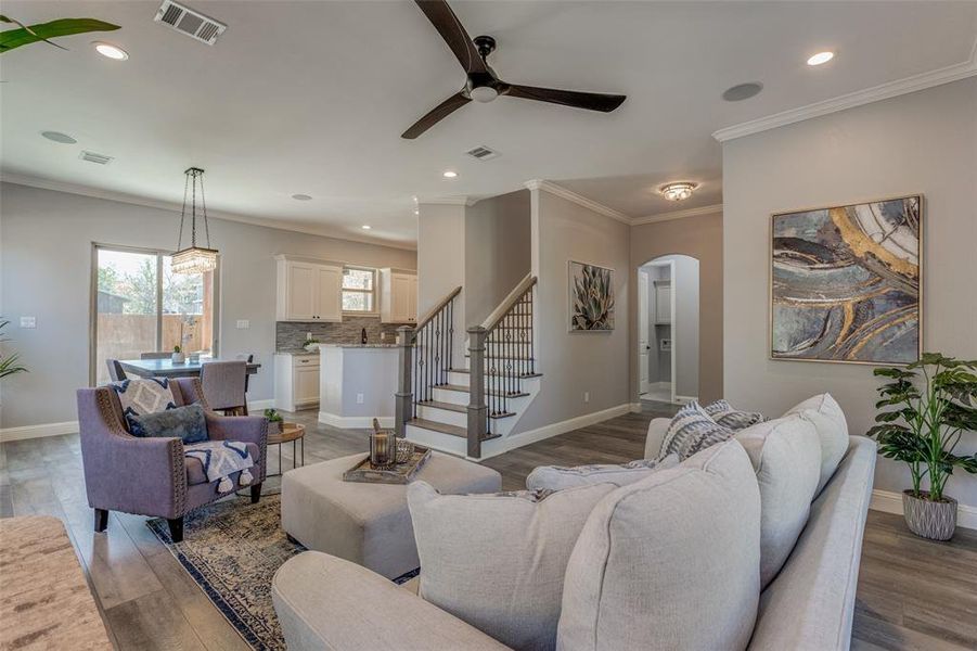 Living room with ceiling fan, hardwood / wood-style flooring, sink, and ornamental molding