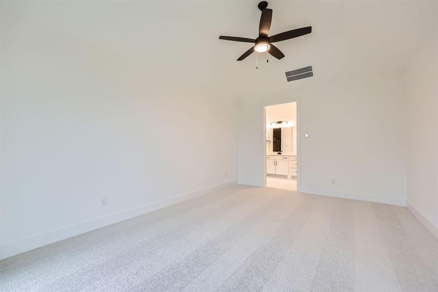 Carpeted empty room featuring a towering ceiling and ceiling fan