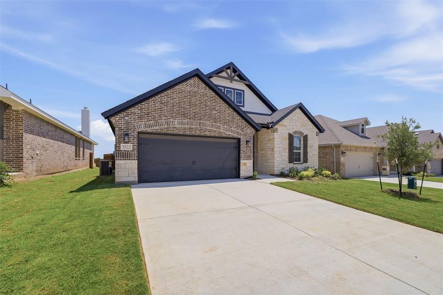 Single-story residence featuring a brick and stone exterior Single-story residence featuring a brick and stone exterior