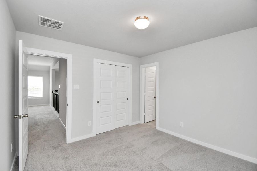 Generously sized secondary bedrooms featuring spacious closets, soft and inviting carpeting underfoot, large windows allowing plenty of natural light, and the added touch of privacy blinds for your personal retreat.