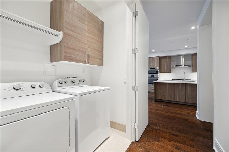 Perfect laundry space with wood cabinetry, shelf and drip dry hanging rod.