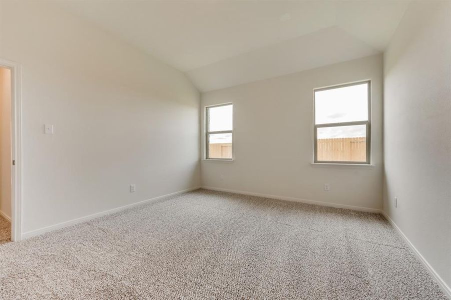 Carpeted empty room with vaulted ceiling