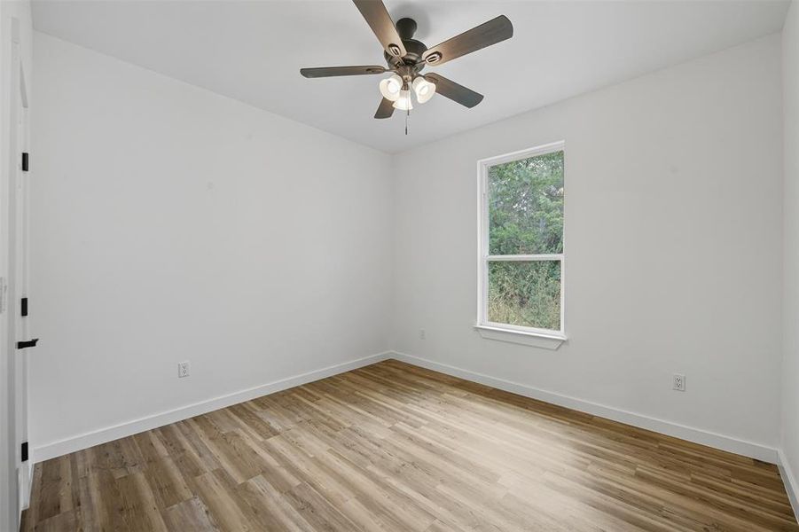 Empty room featuring light wood-style flooring and ceiling fan Empty room featuring light wood-style flooring and ceiling fan