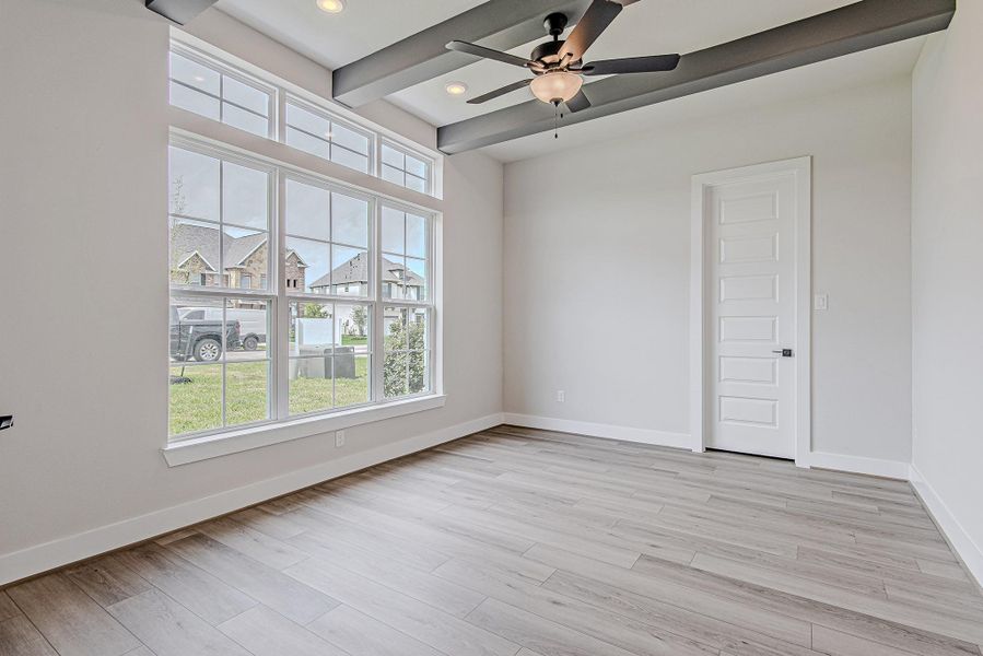 Flex room with large windows, ideal as a home office or additional living space.