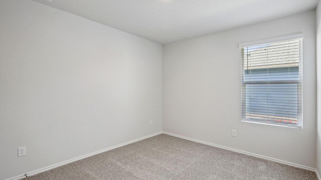 Spare room with baseboards and light colored carpet