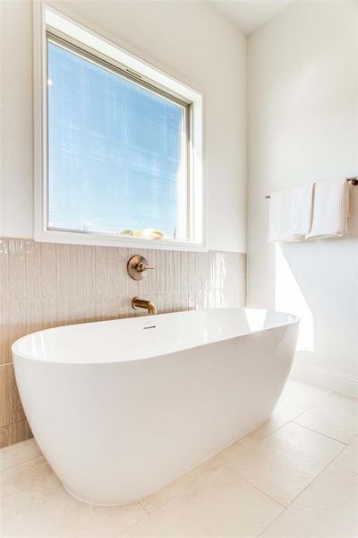 Bathroom with light tile patterned floors and a soaking tub Bathroom with light tile patterned floors and a soaking tub