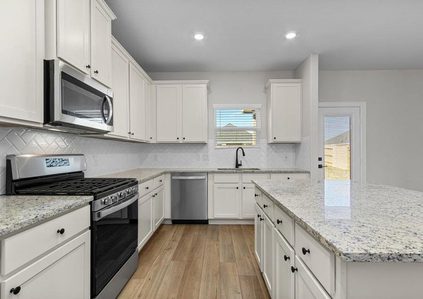 Enjoy stunning granite countertops and designer wood cabinetry in this kitchen.