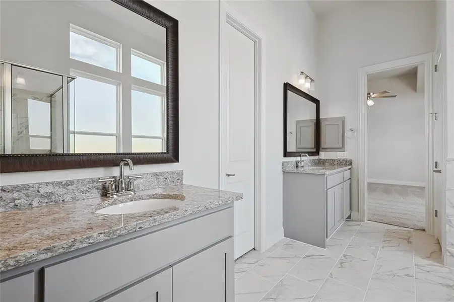 Bathroom with two vanities, light marble finish floors, and a ceiling fan Bathroom with two vanities, light marble finish floors, and a ceiling fan