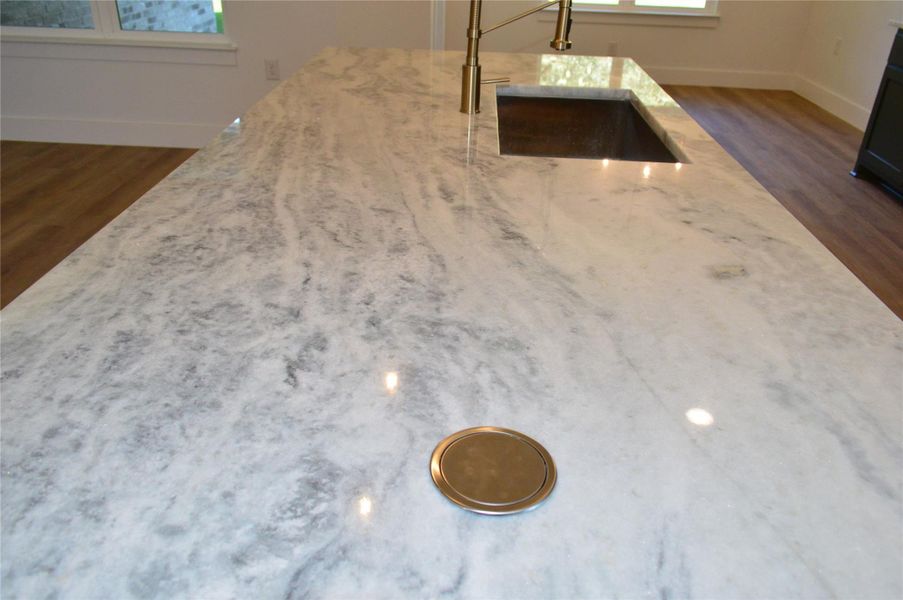 Kitchen view of dark wood-type flooring and light stone countertops Kitchen view of dark wood-type flooring and light stone countertops