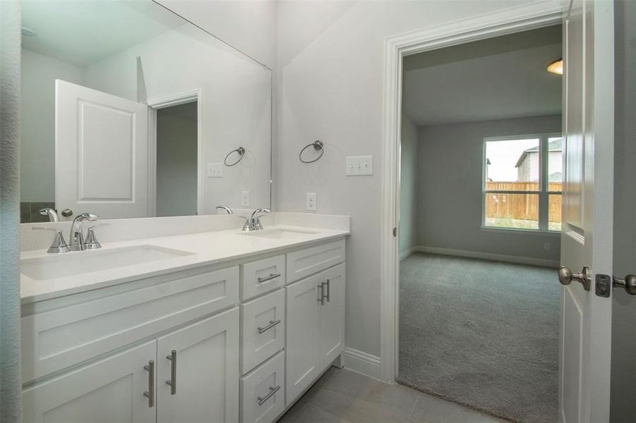 Bathroom featuring double vanity, baseboards, and tile patterned flooring Bathroom featuring double vanity, baseboards, and tile patterned flooring