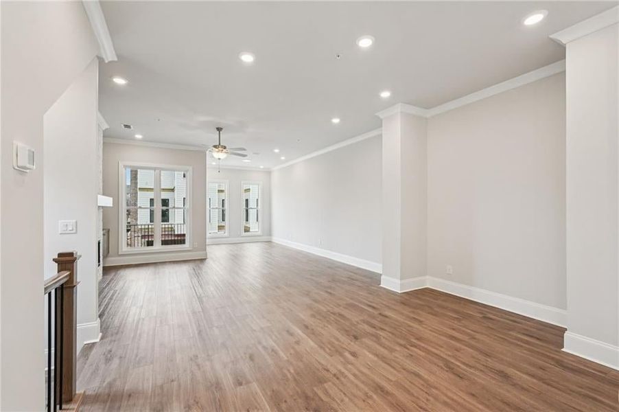Unfurnished living room with recessed lighting, crown molding, light wood finished floors, and ceiling fan