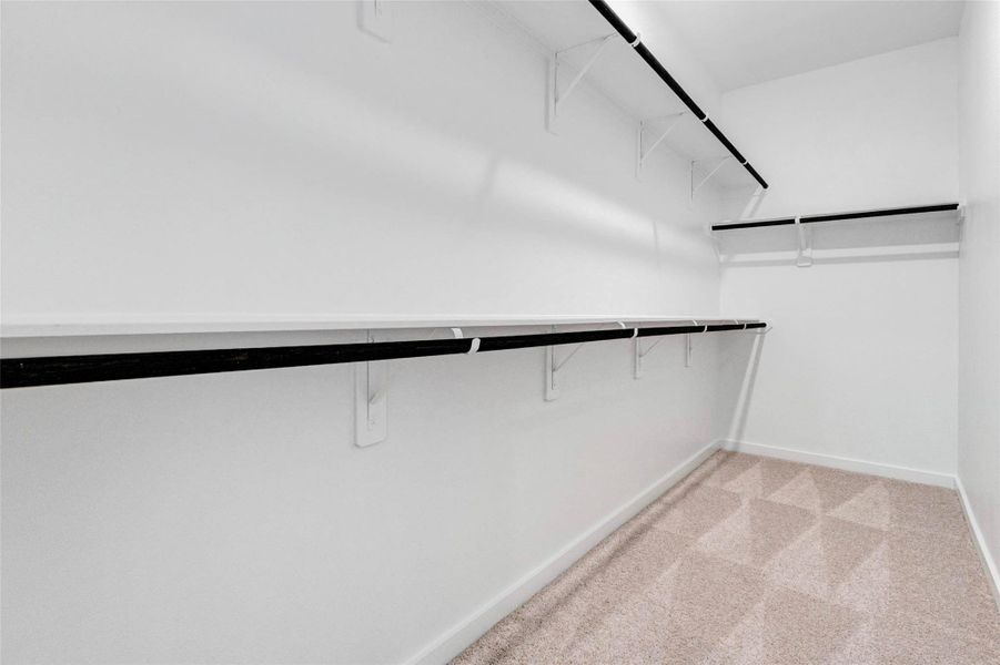 Enjoy ample storage in this spacious walk-in closet, designed with multiple hanging rods and shelving to maximize organization. The clean, bright space offers plenty of room for wardrobes of all sizes, while the thoughtful layout ensures easy accessibility. This closet provides both function and flexibility to keep everything neatly arranged.