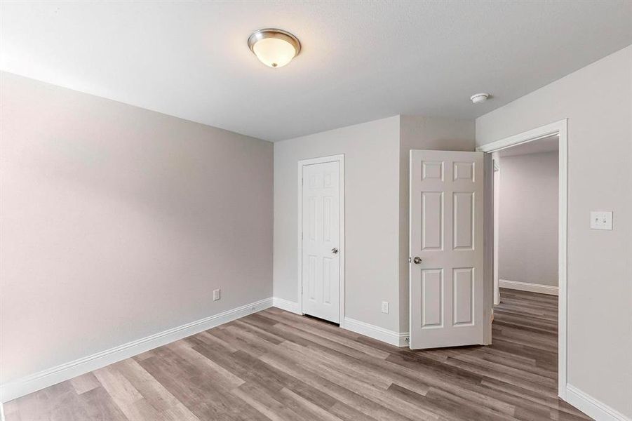 Unfurnished bedroom featuring light hardwood / wood-style flooring and a closet