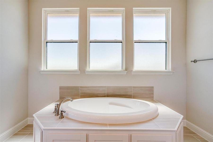 Bathroom featuring a tub to relax in and a wealth of natural light