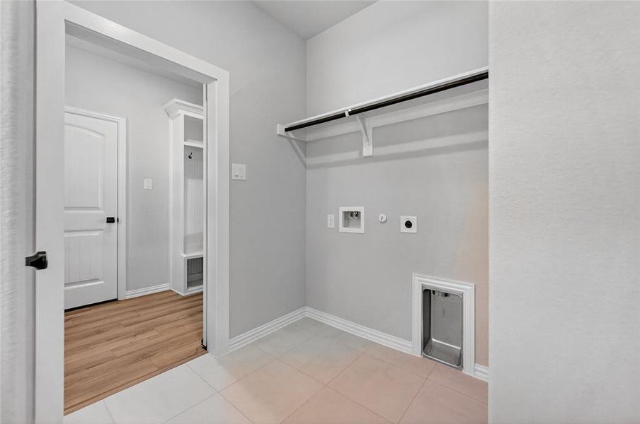 Laundry area with gas dryer hookup, hookup for a washing machine, light tile patterned floors, and electric dryer hookup Laundry area with gas dryer hookup, hookup for a washing machine, light tile patterned floors, and electric dryer hookup