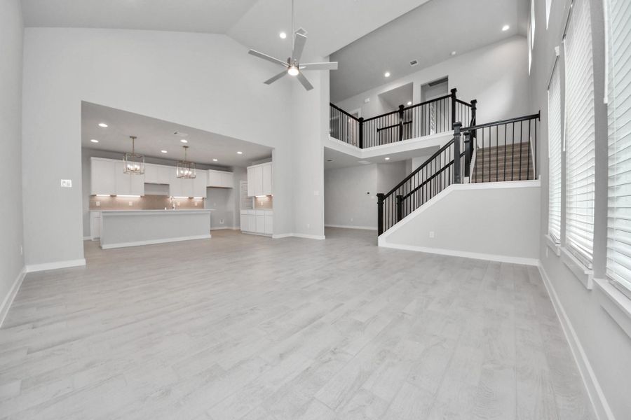 Welcome family and guests to your charming living room! With its high ceilings, recessed lighting, ceiling fan, custom paint, beautiful flooring, and large windows that let in abundant natural light, this room is perfect for gatherings. Sample photo of completed home with similar floor plan. Actual colors and selections may vary.
